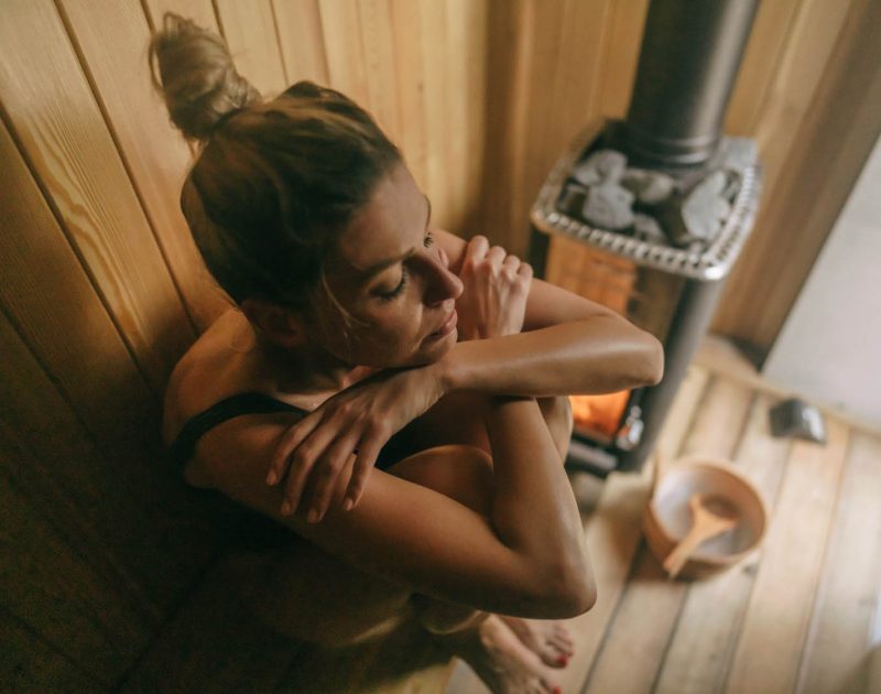 Photo of a young woman relaxing in sauna she is at and enjoying her spa day