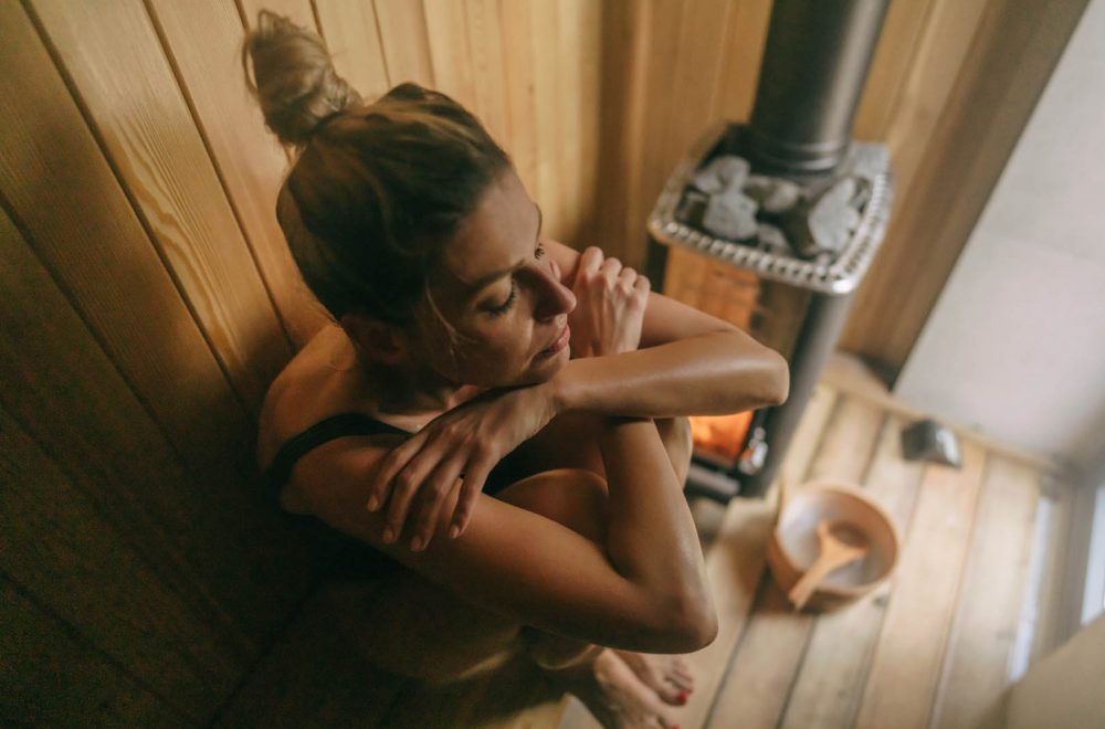 Photo of a young woman relaxing in sauna she is at and enjoying her spa day